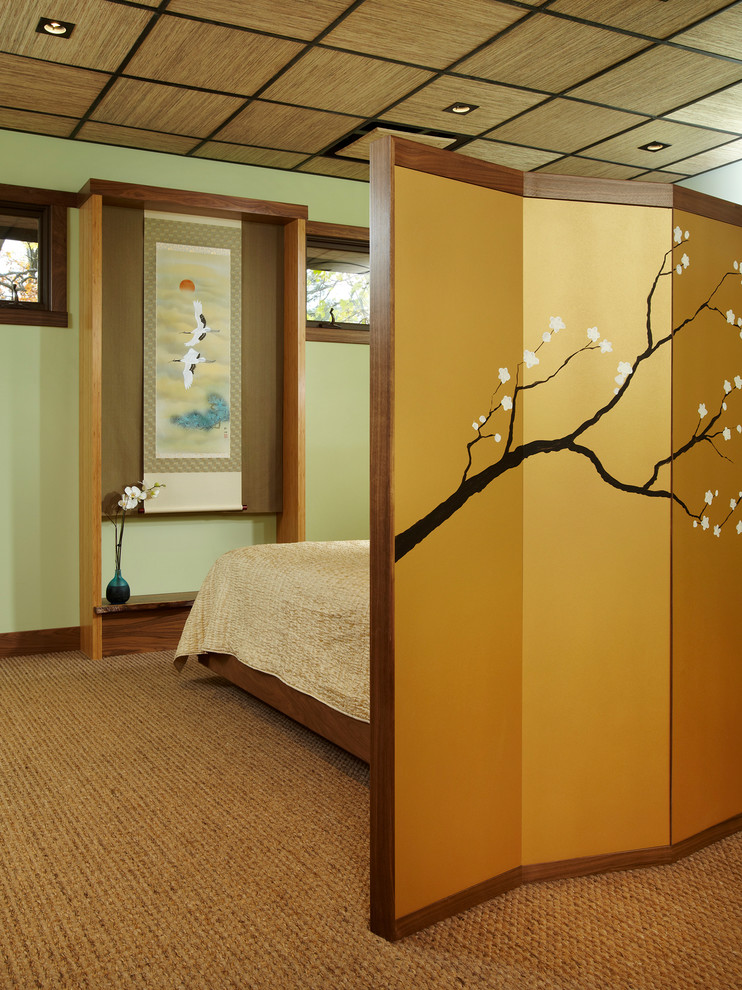 This is an example of a medium sized world-inspired bedroom in Chicago with green walls and carpet.