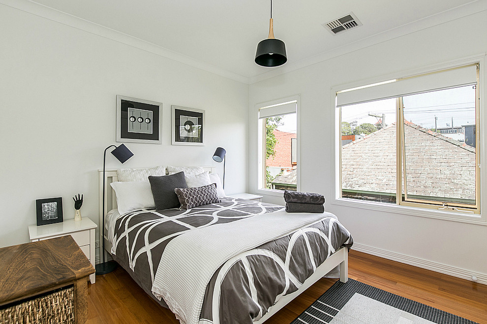 Foto de habitación de invitados contemporánea de tamaño medio con paredes blancas y suelo de madera en tonos medios
