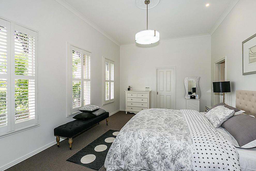 Ejemplo de dormitorio principal actual de tamaño medio con paredes blancas y moqueta