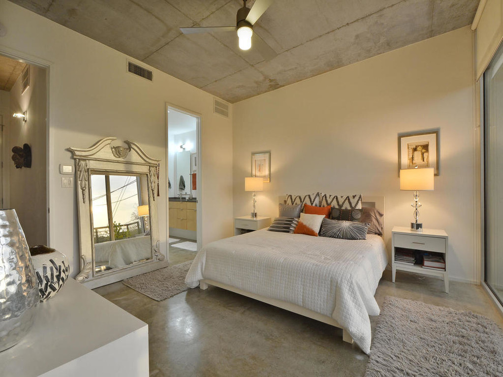Modernes Hauptschlafzimmer ohne Kamin mit weißer Wandfarbe und Betonboden in Austin