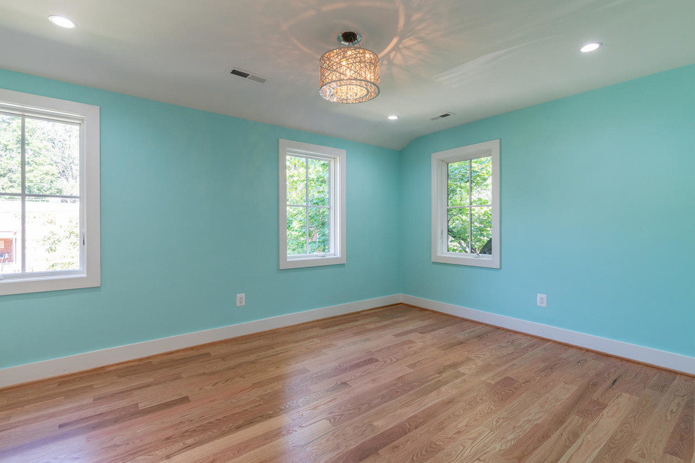 Exemple d'une chambre de taille moyenne avec un mur bleu, un sol en bois brun et un sol marron.