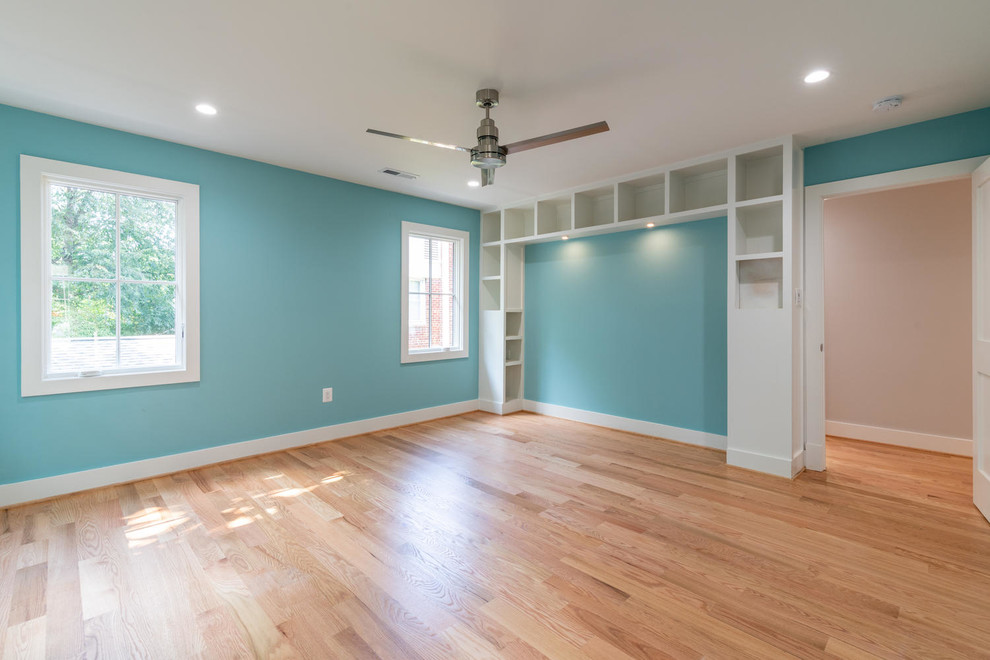 Cette photo montre une chambre de taille moyenne avec un mur bleu, un sol en bois brun et un sol marron.