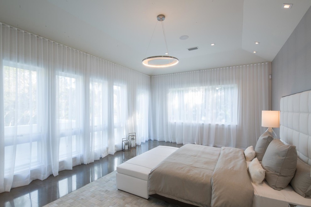 Medium sized contemporary master bedroom in Miami with grey walls, no fireplace and brown floors.
