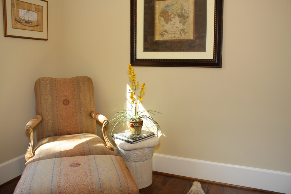 Idée de décoration pour une chambre parentale tradition de taille moyenne avec un mur jaune et un sol en bois brun.
