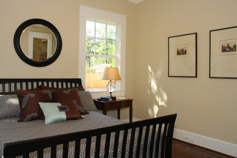Idées déco pour une chambre parentale classique de taille moyenne avec un mur jaune et un sol en bois brun.