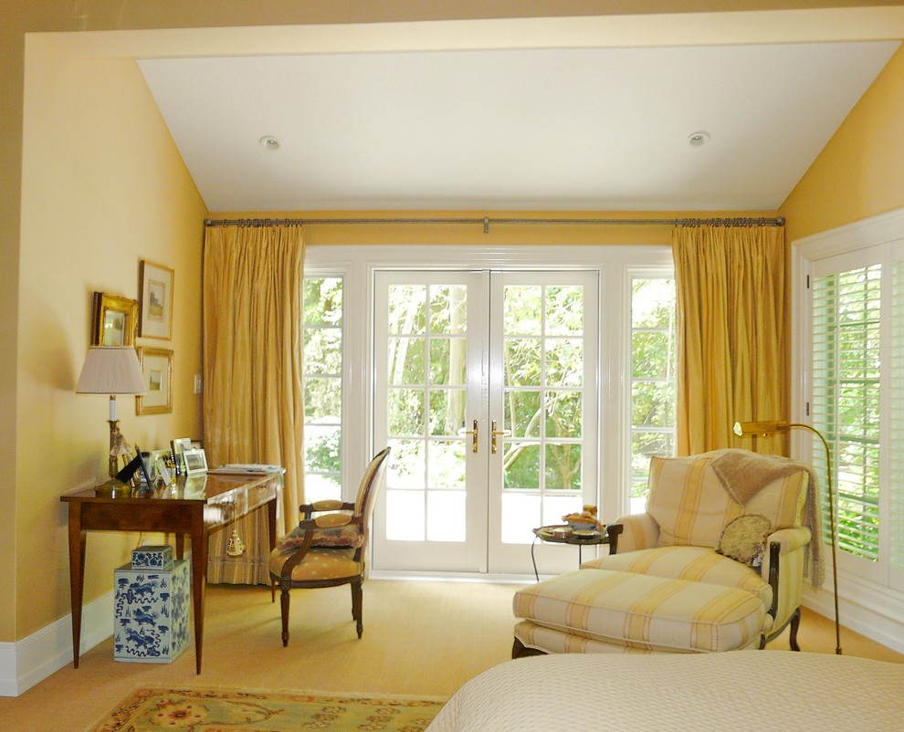 Идея дизайна: большая хозяйская спальня в классическом стиле с желтыми стенами, ковровым покрытием, стандартным камином и фасадом камина из камня