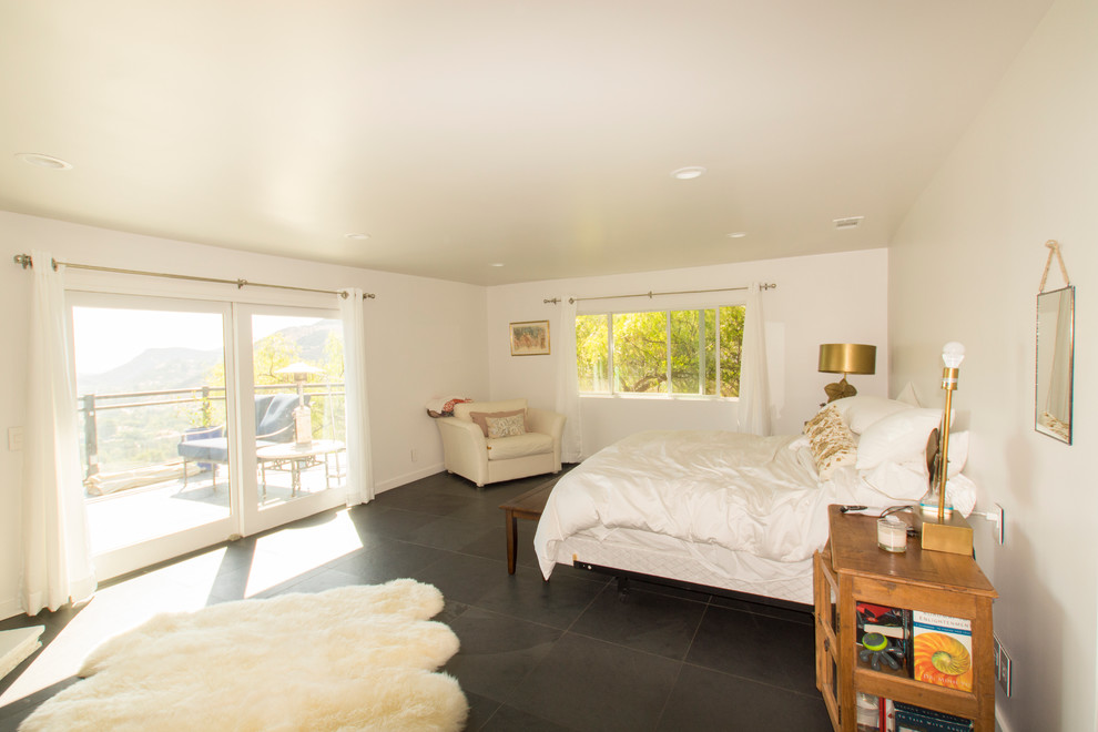 На фото: хозяйская спальня среднего размера в стиле модернизм с белыми стенами, полом из керамической плитки и черным полом без камина с