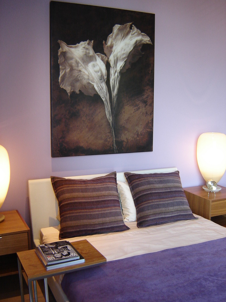 Imagen de dormitorio principal de estilo americano grande sin chimenea con paredes púrpuras y suelo de cemento