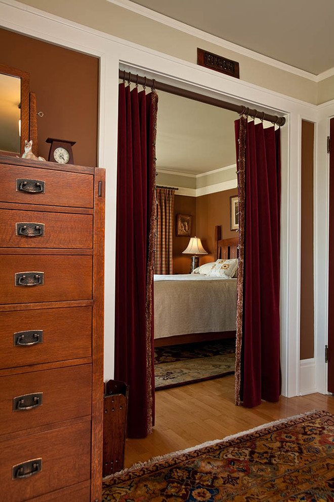 ミネアポリスにあるトラディショナルスタイルのおしゃれな主寝室 (茶色い壁、無垢フローリング、暖炉なし、間仕切りカーテン) のインテリア
