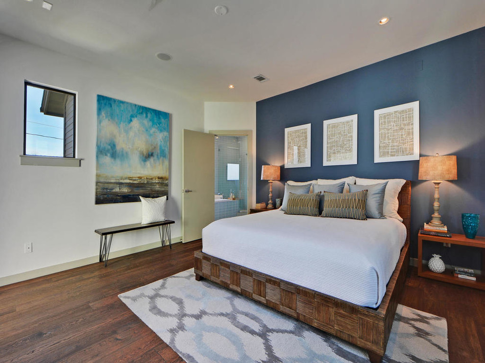 Mid-sized transitional master medium tone wood floor bedroom photo in Austin with blue walls