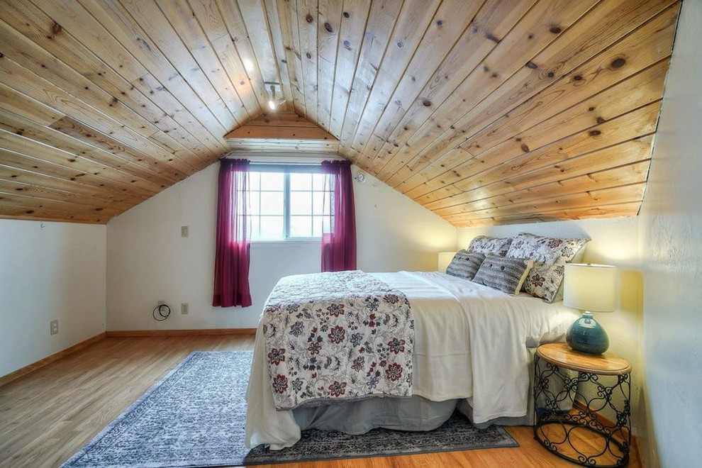 Imagen de dormitorio tipo loft clásico pequeño con paredes beige y suelo de madera clara
