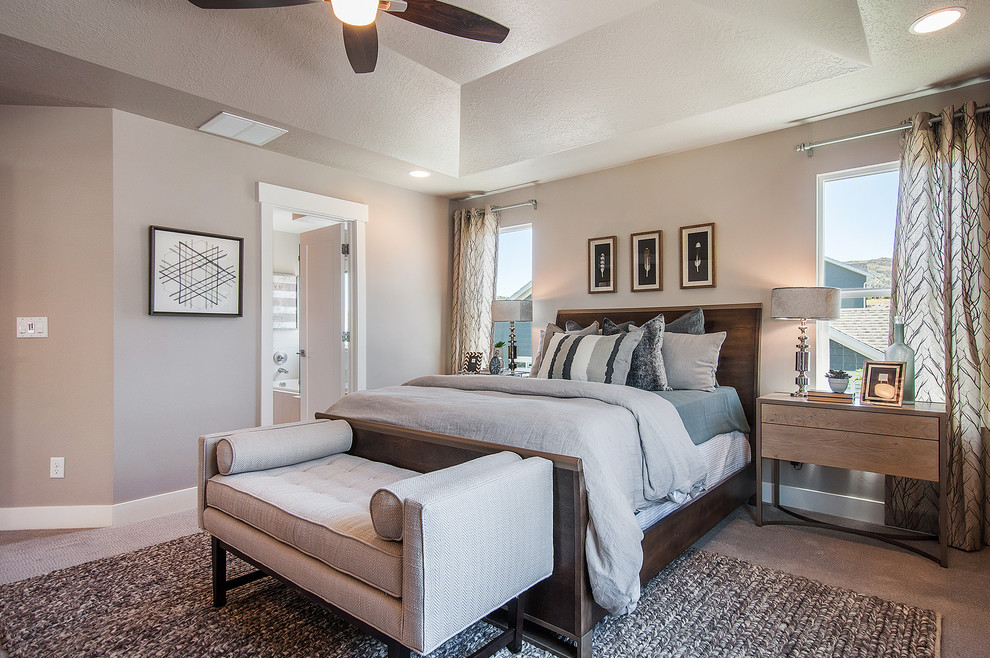 This is an example of a large contemporary master bedroom in Salt Lake City with beige walls, carpet, no fireplace and brown floors.
