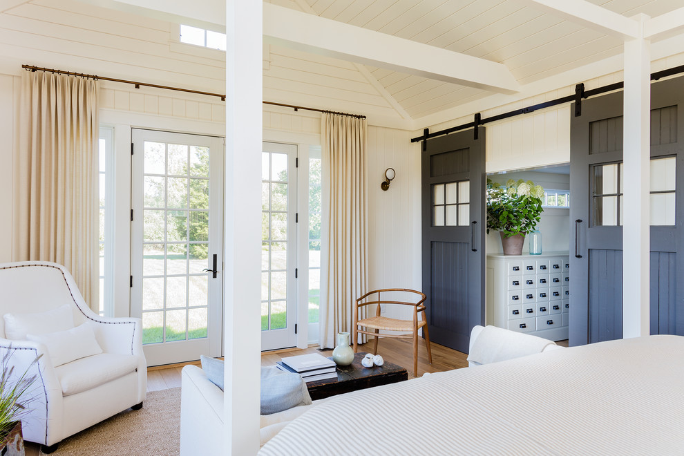 Example of a transitional master light wood floor bedroom design in Boston with white walls