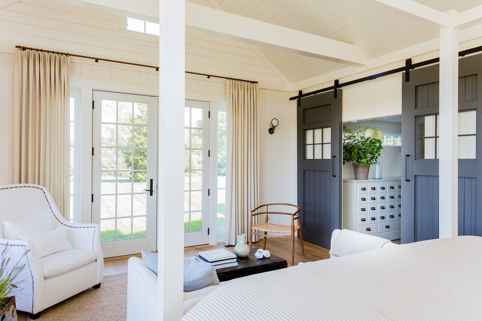 Diseño de dormitorio principal tradicional renovado con paredes blancas y suelo de madera clara