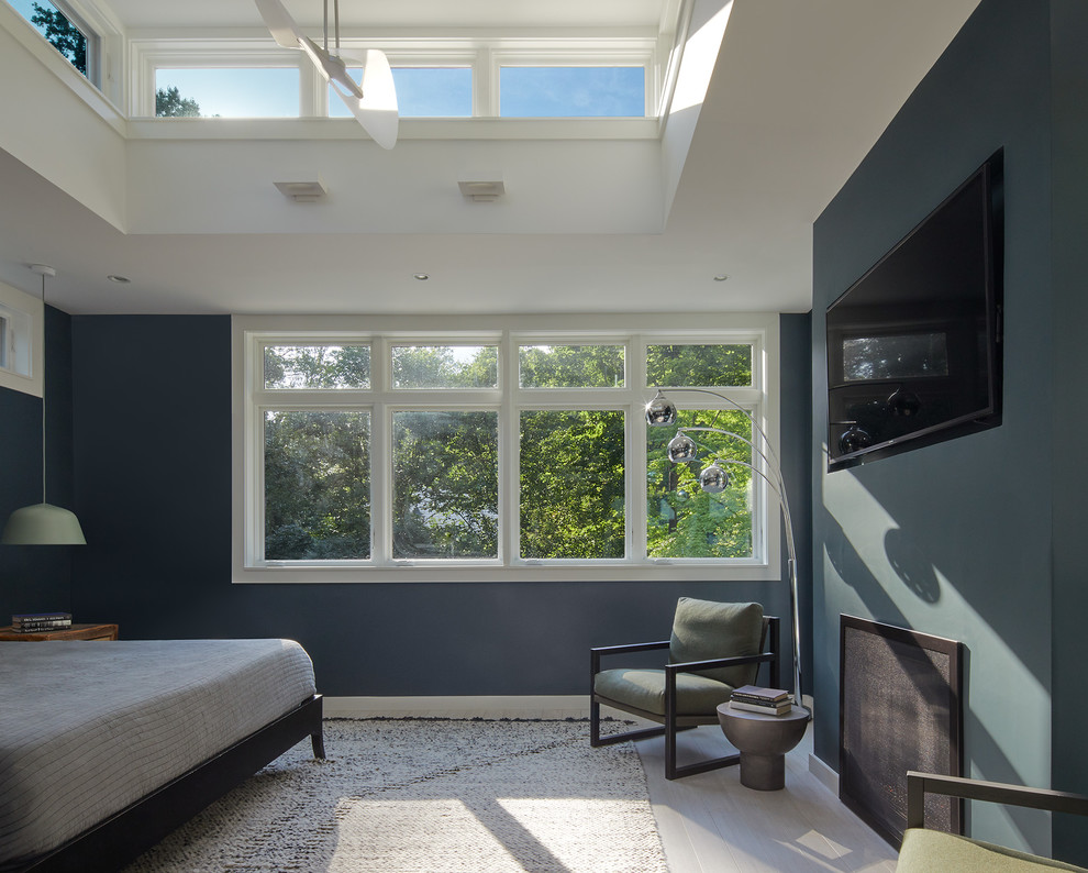 Источник вдохновения для домашнего уюта: спальня в современном стиле с синими стенами, деревянным полом, стандартным камином и белым полом