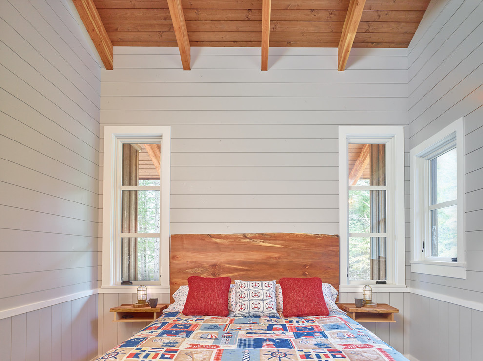 Diseño de dormitorio principal rural de tamaño medio con paredes grises, suelo de madera en tonos medios y suelo marrón
