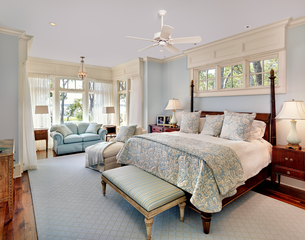 Klassisches Schlafzimmer ohne Kamin mit blauer Wandfarbe und braunem Holzboden in Charleston