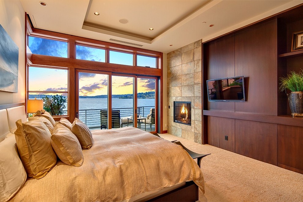 Modernes Gästezimmer mit beiger Wandfarbe, Teppichboden, Kamin und Kaminumrandung aus Stein in Seattle