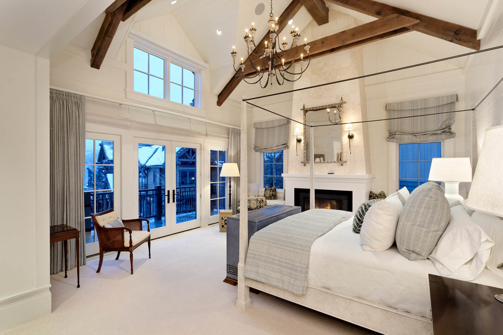 На фото: хозяйская спальня в стиле кантри с белыми стенами, стандартным камином и белым полом с