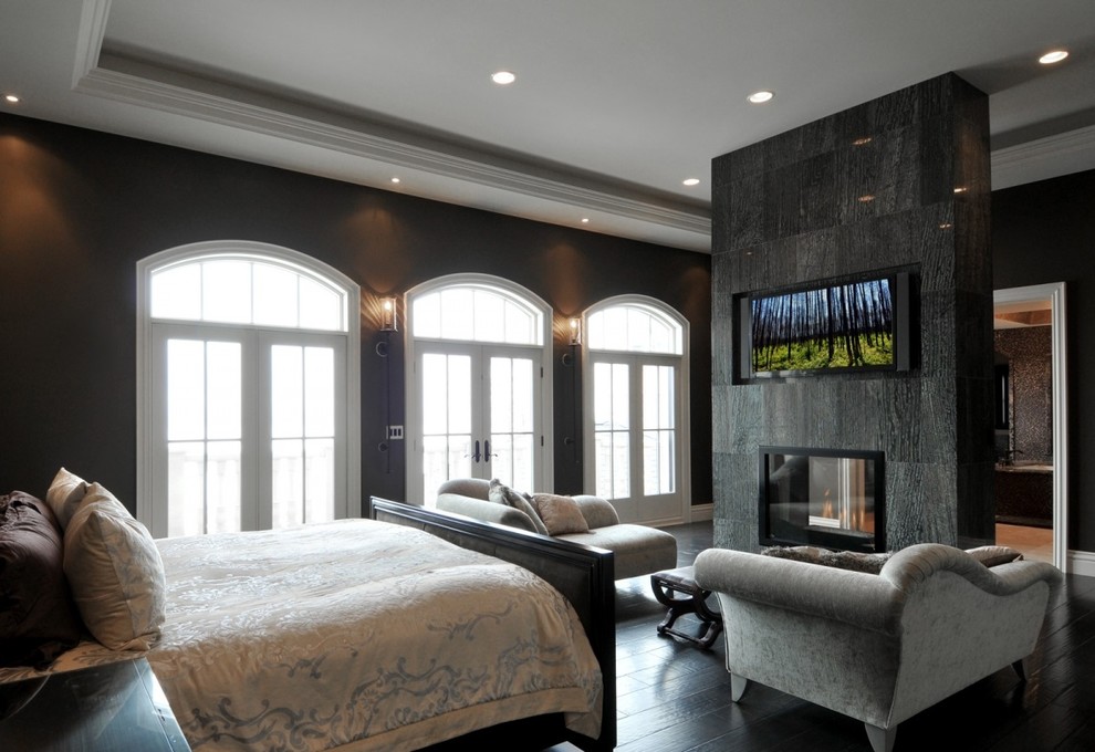 На фото: хозяйская спальня в современном стиле с темным паркетным полом с