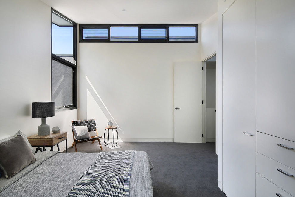 メルボルンにある広いコンテンポラリースタイルのおしゃれな客用寝室 (白い壁、カーペット敷き、暖炉なし、グレーの床) のレイアウト
