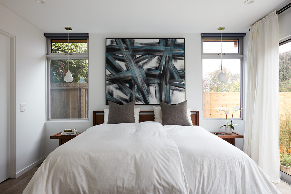 Imagen de dormitorio principal actual de tamaño medio con paredes blancas, suelo de madera clara y suelo beige