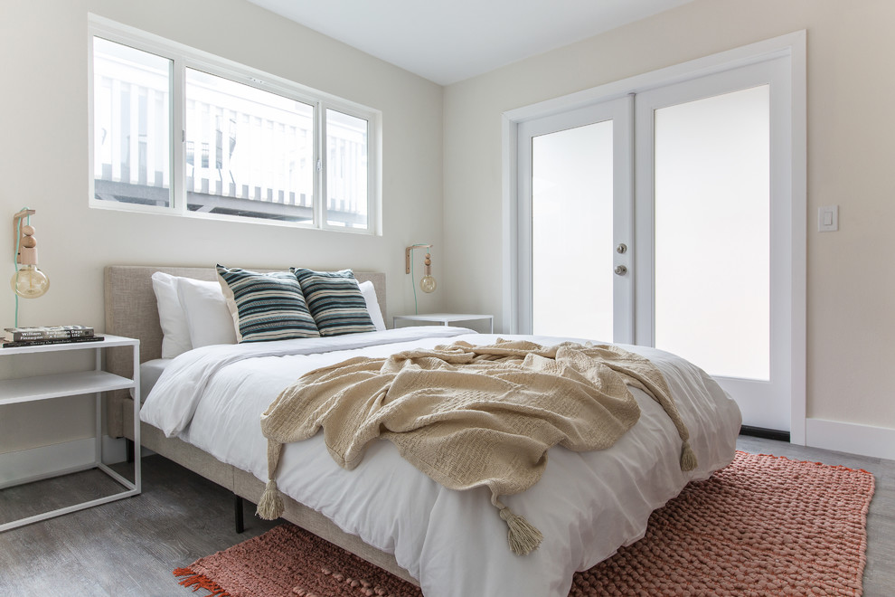 Modelo de habitación de invitados clásica renovada con paredes beige, suelo de madera en tonos medios y suelo gris