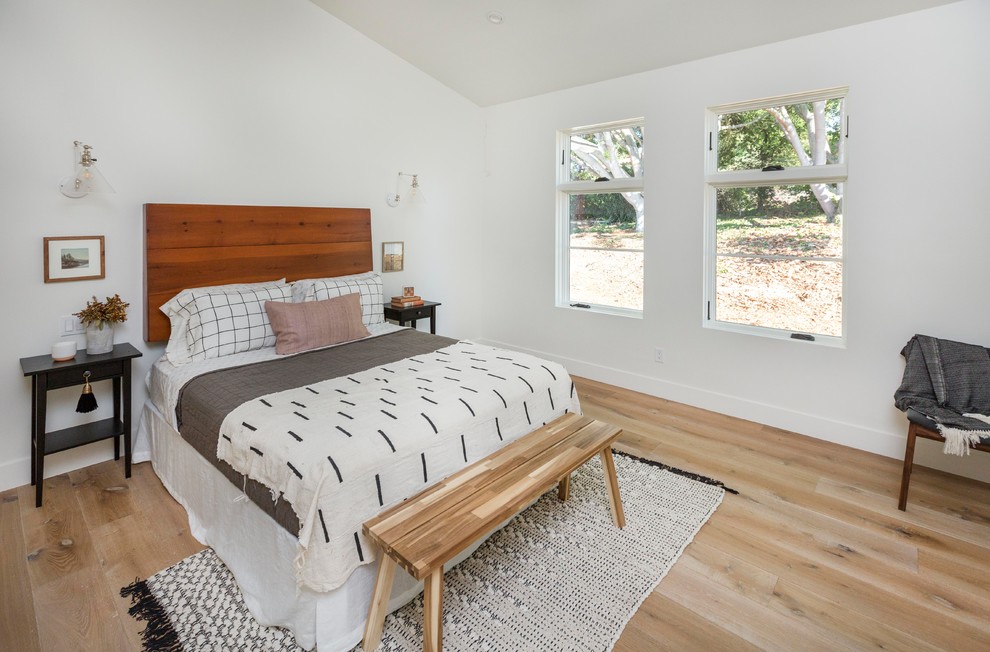 Diseño de habitación de invitados campestre grande con paredes blancas, suelo de madera clara y suelo beige