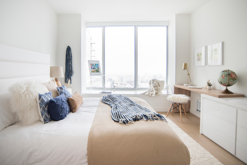 Modelo de dormitorio principal nórdico de tamaño medio sin chimenea con paredes blancas, suelo de madera clara y suelo beige