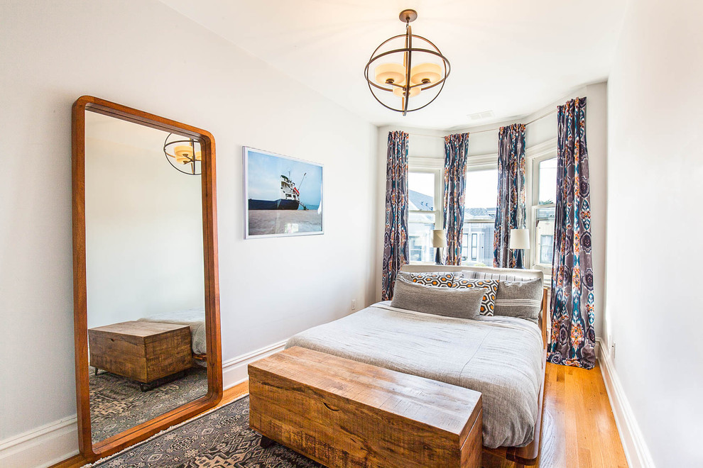 Ejemplo de habitación de invitados clásica renovada con paredes blancas, suelo de madera en tonos medios y suelo amarillo