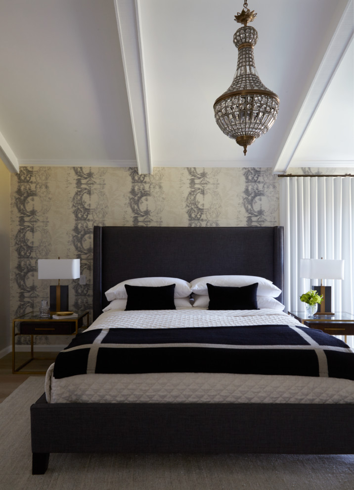 Modelo de dormitorio principal clásico renovado grande con paredes beige y suelo de madera clara