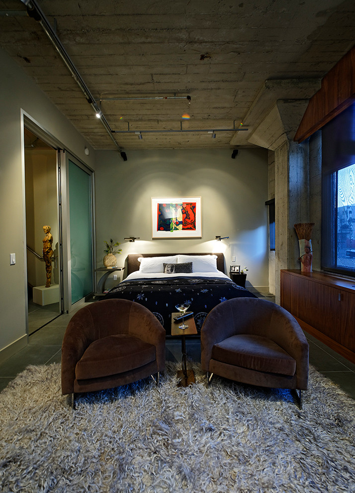 Immagine di una camera da letto industriale con pareti grigie