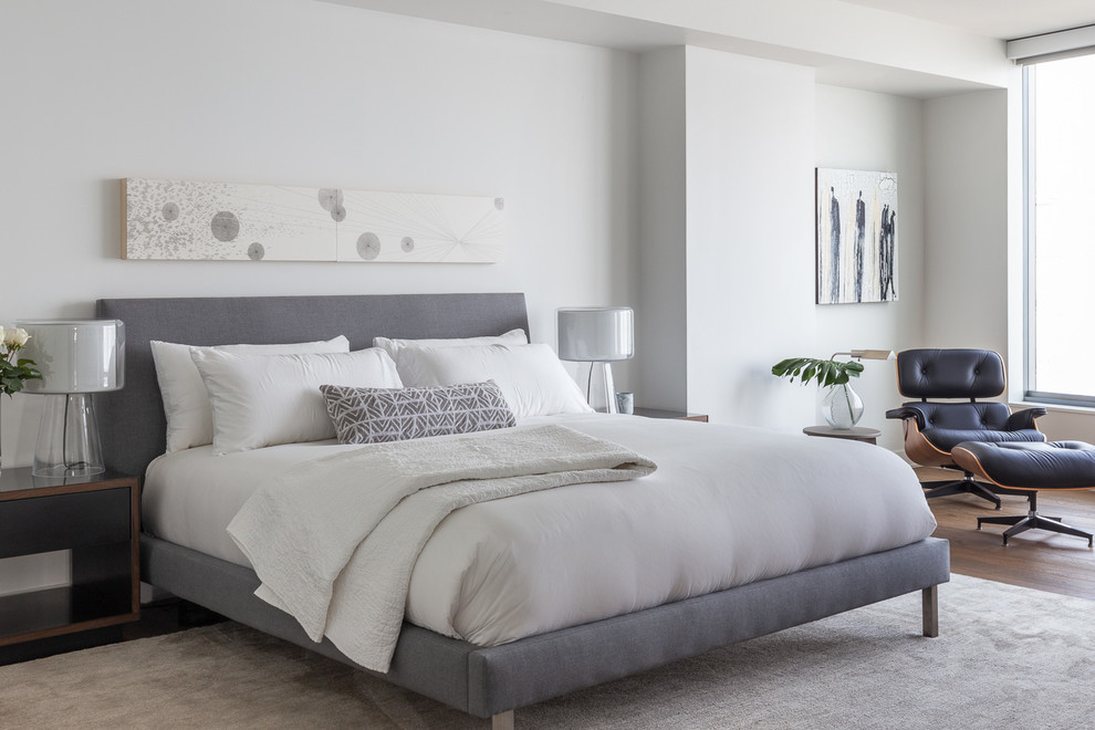 Modernes Schlafzimmer mit weißer Wandfarbe, braunem Holzboden und braunem Boden in Sacramento