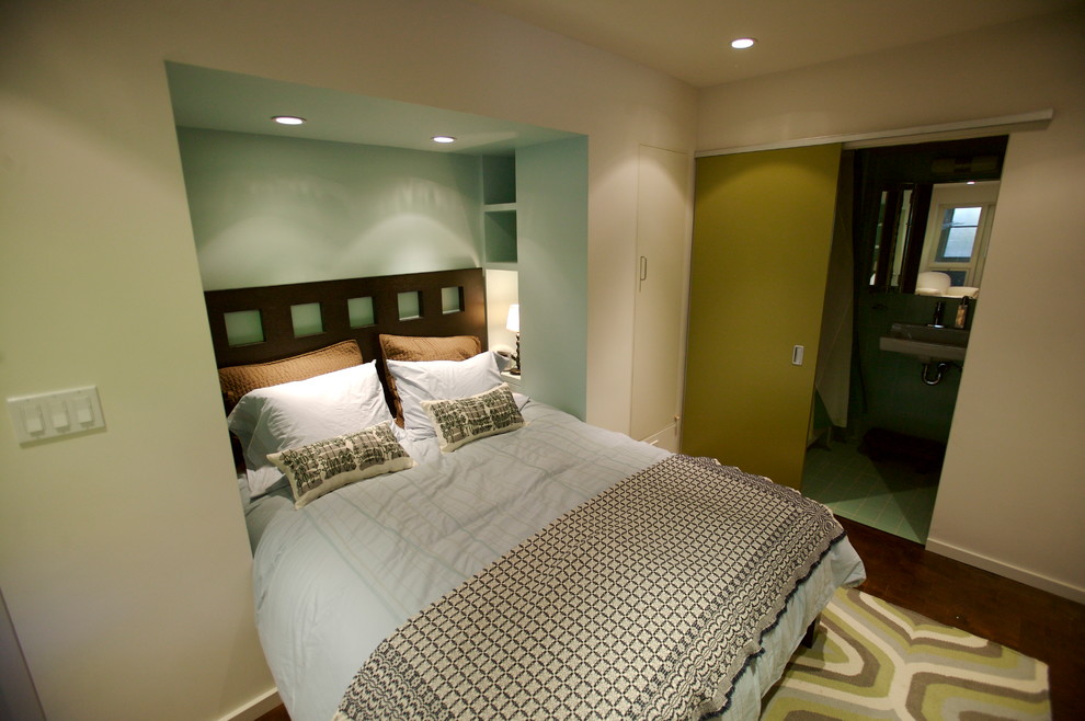 Exemple d'une chambre d'amis tendance de taille moyenne avec un mur bleu, parquet foncé et aucune cheminée.