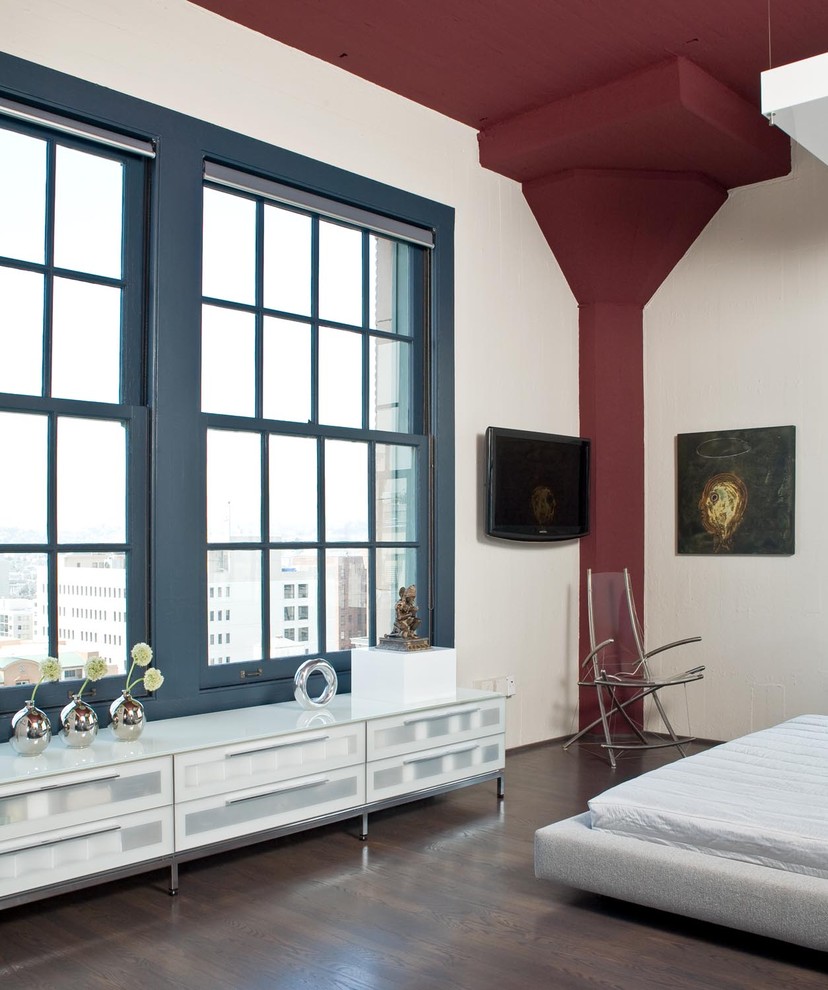 Источник вдохновения для домашнего уюта: спальня в стиле модернизм с белыми стенами, темным паркетным полом и телевизором
