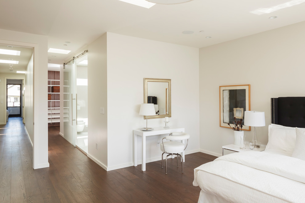Imagen de habitación de invitados actual de tamaño medio sin chimenea con paredes blancas, suelo de madera oscura y suelo marrón