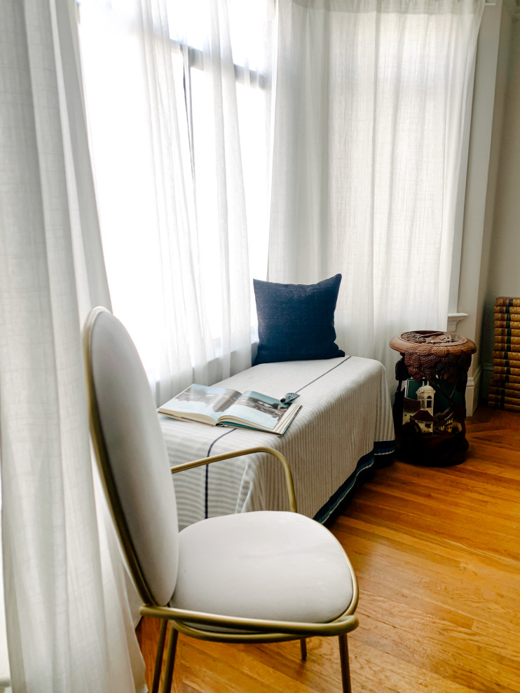 Modelo de dormitorio principal y abovedado asiático de tamaño medio sin chimenea con paredes azules, suelo de madera en tonos medios y suelo marrón