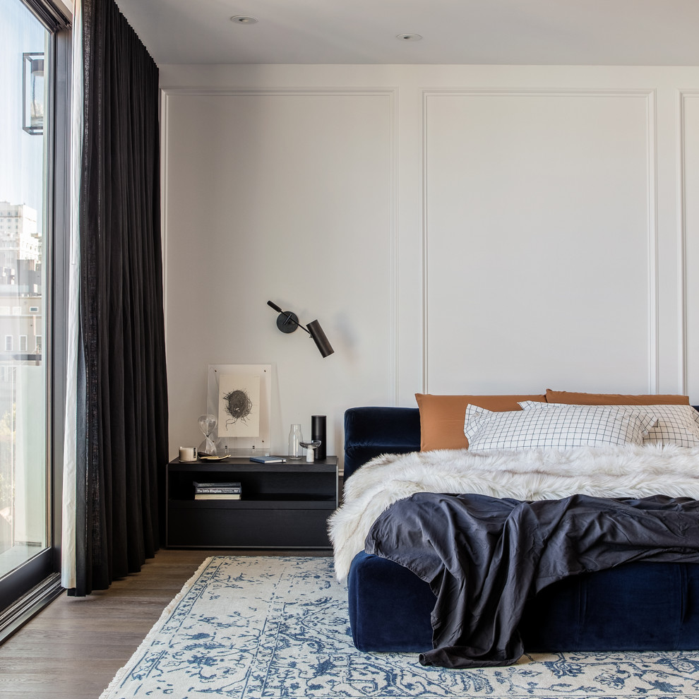 Contemporary bedroom in San Francisco with white walls, medium hardwood flooring and brown floors.