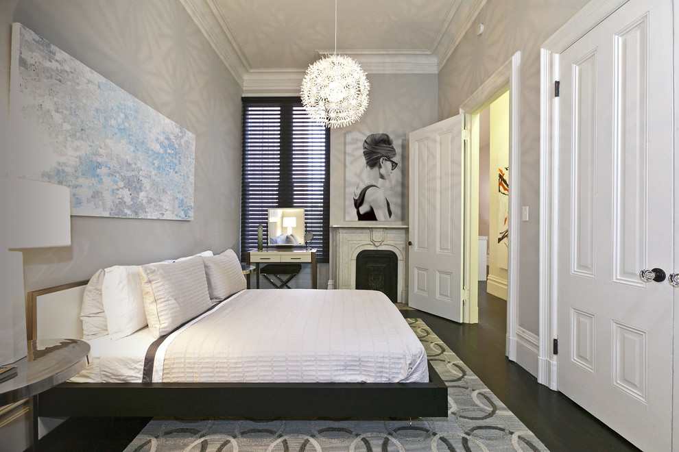 Foto di una camera da letto contemporanea con pareti grigie, parquet scuro e camino classico