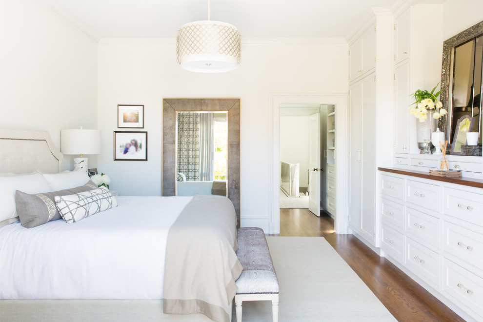 Ejemplo de dormitorio clásico renovado con paredes blancas, suelo de madera en tonos medios y suelo marrón