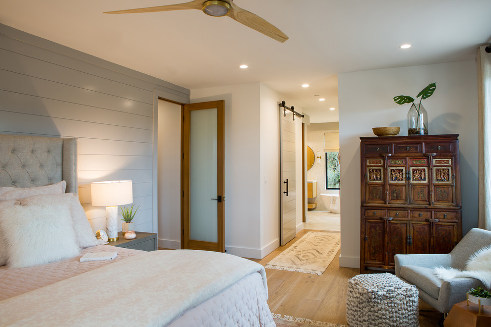 Foto de habitación de invitados tradicional renovada de tamaño medio sin chimenea con paredes grises, suelo de madera clara y suelo beige