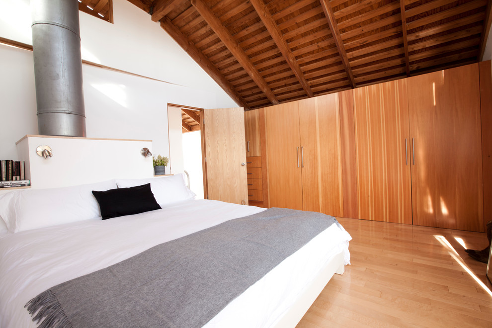 Modernes Schlafzimmer mit weißer Wandfarbe und braunem Holzboden in Los Angeles