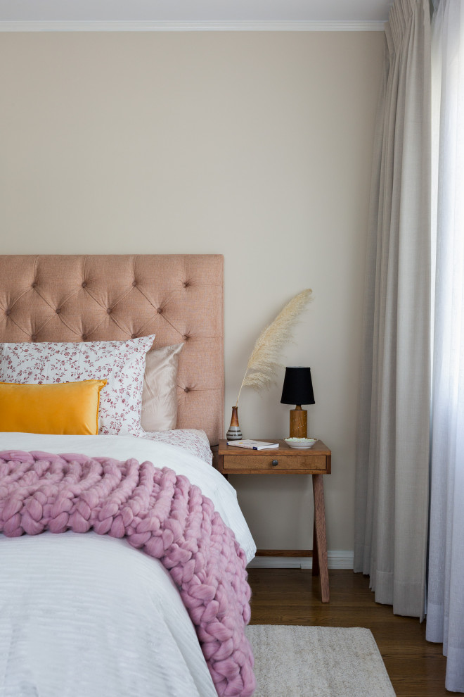 Immagine di una piccola camera degli ospiti design con pareti beige, pavimento in legno massello medio, pavimento marrone e abbinamento di mobili antichi e moderni
