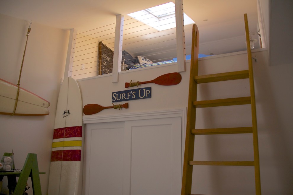 Foto de dormitorio tipo loft costero de tamaño medio con paredes blancas y suelo de madera clara