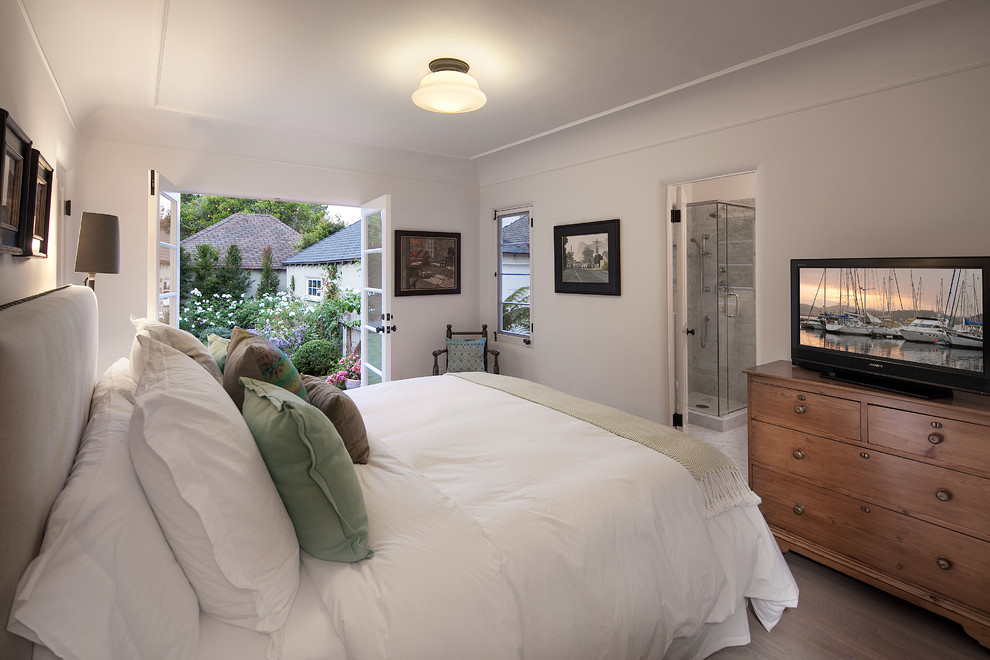 Imagen de dormitorio principal clásico renovado sin chimenea con paredes blancas y suelo de madera en tonos medios