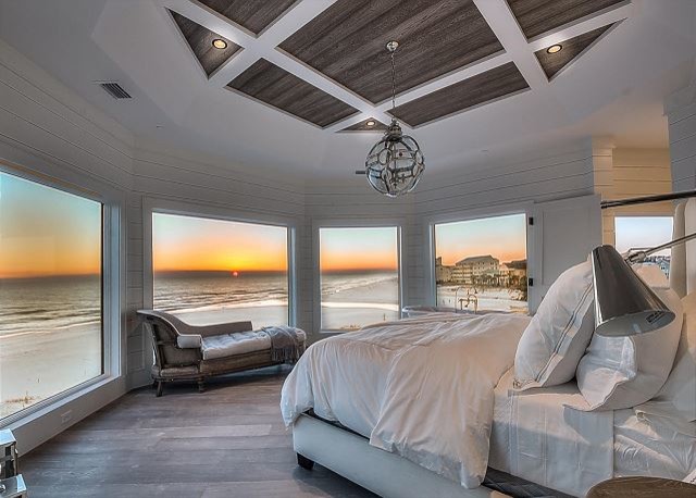 Foto de dormitorio principal costero de tamaño medio sin chimenea con paredes blancas y suelo de madera en tonos medios