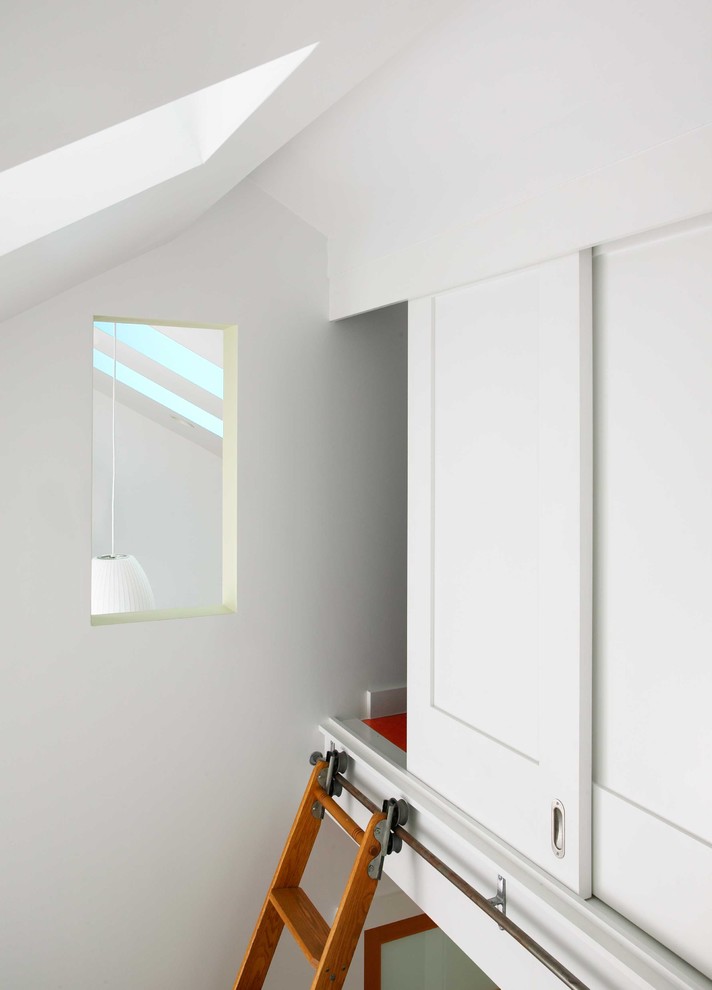 Aménagement d'une petite chambre parentale contemporaine avec un mur blanc, un sol en bois brun et aucune cheminée.
