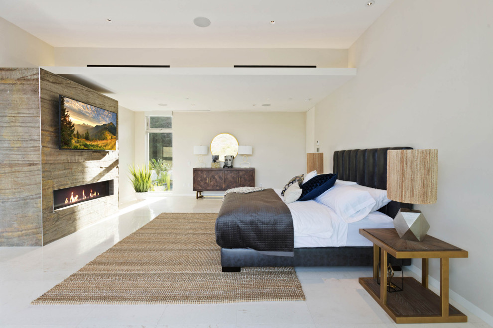 ロサンゼルスにある広いコンテンポラリースタイルのおしゃれな主寝室 (白い壁、磁器タイルの床、横長型暖炉、石材の暖炉まわり、白い床) のレイアウト