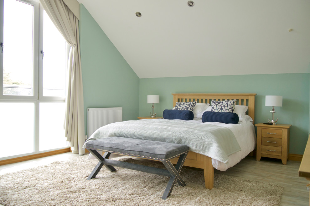 ドーセットにあるビーチスタイルのおしゃれな主寝室 (緑の壁、クッションフロア)