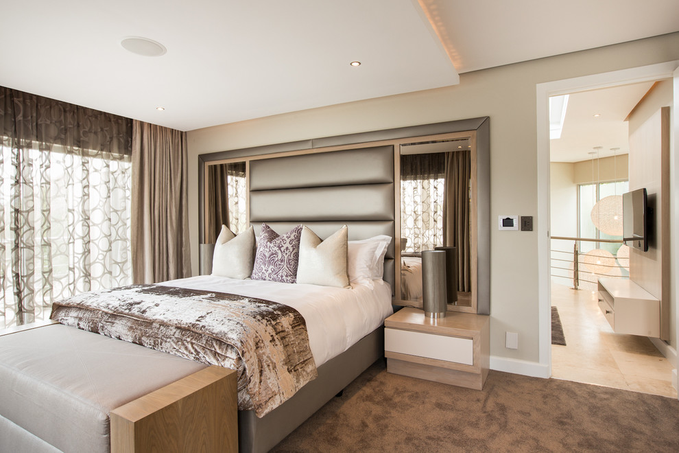 Contemporary master bedroom with beige walls and carpet.